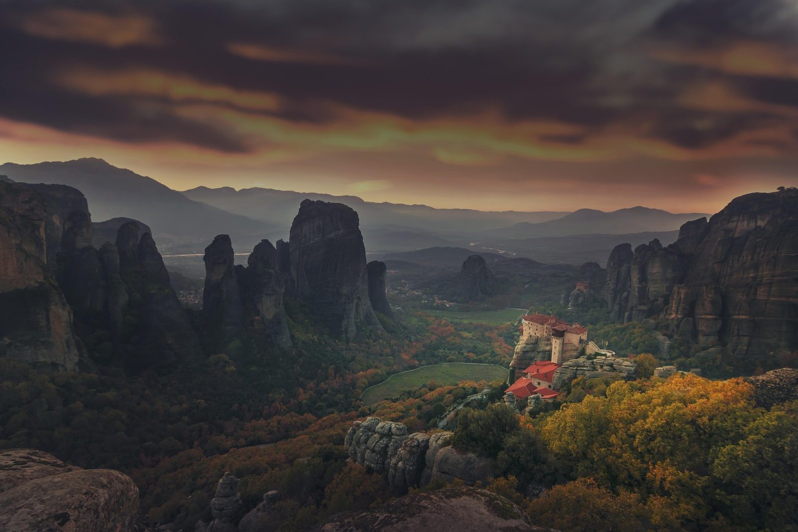 Autumn leaves in front of the Meteora rock formations at sunrise